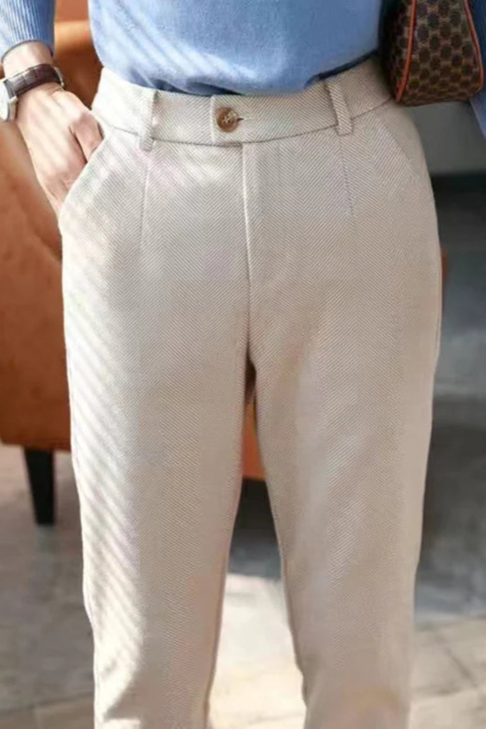 Person wearing beige pants and a blue shirt in an indoor setting
